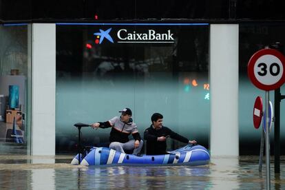 Dos jóvenes utilizan un bote hinchable en una calle inundada en Pamplona (Navarra). Durante la noche, la situación ha ido empeorando en Gipuzkoa, con especial fuerza en zonas del Deba y el Bidasoa.