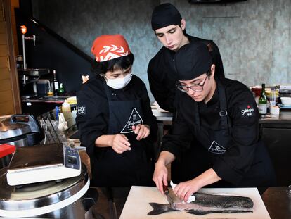 Dos alumnos de los cursos de cocina japonesa de Gakko Japo, en Madrid, con su profesora Sonomi Tsuchiya.