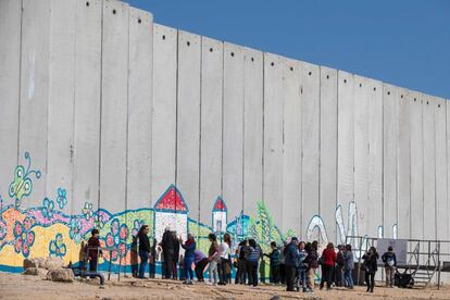 El fotógrafo Roi Kuper, nacido en un kibbutz próximo a la franja de Gaza en 1956, expuso hace dos años en el Museo de Israel de Jerusalén la obra que bautizó como ‘El Sueño de Gaza’. Poco antes de que estallara la última guerra, recorrió con su cámara el perímetro terrestre del enclave costero palestino y plasmó una sucesión de imágenes desde la distancia que reflejaban la vida al otro lado de la frontera. Acabados los 50 días de la Operación Margen Protector —un conflicto que se saldó con la muerte de 2.250 palestinos (tres quintas partes de ellos civiles, entre ellos 550 niños) y de 73 israelíes, de los que 67 eran militares— Kuper regresó para completar su trabajo, pero tras el muro ya solo halló desolación. Las fotografías del artista israelí reflejan fielmente la sensación de espejismo que rodea la franja de Gaza entre verjas, vallas, muros de cemento y torreones, y con el siniestro paso de cruce para civiles de Erez. En el horizonte emergen grandes construcciones y barriadas en las que se hacinan 1,8 millones de palestinos sometidos a bloqueo terrestre y naval por Israel desde hace una década, con la cooperación de Egipto en el flanco sur. Bajo esa frontera y sus muros, túneles excavados por las milicias de Hamás penetran en territorio israelí y siembran el temor entre los habitantes de los kibutz judíos. La destrucción de esas galerías fue la principal razón esgrimida por Israel para desencadenar la guerra en 2014. Pero hoy al menos la mitad de los túneles aún siguen operativos. En la imagen, un grupo de turistas israelíes en Netiv Haashara./ J. C. SANZ (Jerusalén)