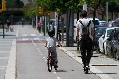 Un niño monta en bicicleta junto a su padre, que va en patinete.