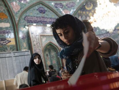 Una mujer iraní deposita su voto en una urna de un centro electoral en Teherán.