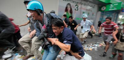 Un fotógrafo ayuda a un manifestante antigubernamental herido por los soldados en el centro de Bangkok.
