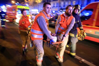 Una mujer es evacuada de Bataclan tras el atentado.