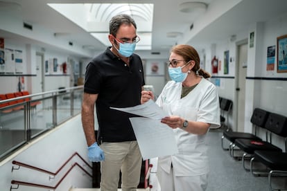 José Eloy Durán and Carmen Recio, coordinator and pharmacist at the public health center in Navas del Madroño, as they review the list of one positive patient’s close contacts. 