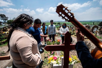 Una familia visita el cementerio de San Miguel Xico el 5 de agosto de 2020, en medio de la pandemia del coronavirus.