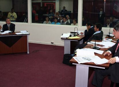 El fiscal Avelino Guillén, a la derecha en primer plano, interroga al ex presidente Fujimori, a la izquierda, sentado al fondo de la sala del juicio.