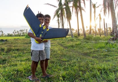 Dos niños filipinos sostienen uno de los artefactos no tripulados que la ONG suiza MEDAIR junto con Drone Adventures usaron en 2014 para cartografiar las áreas afectadas por el tifón Yolanda.