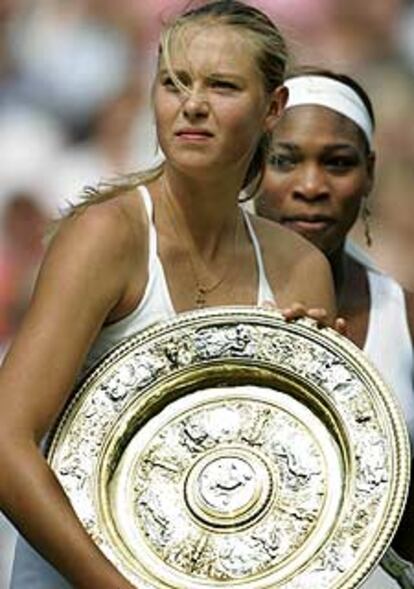 Sharapova, con el trofeo de campeona, y detrás, Serena Williams.