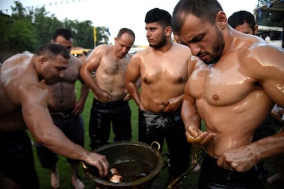 Unos luchadores se cubren conl aceite antes de tomar parte en una competición tradicional de lucha, en la aldea de Sohos (Grecia).