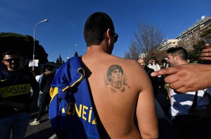 Un fan de Boca Juniors muestra la imagen del futbolista argentino Diego Armando Maradona que tiene tatuado en su espalda.