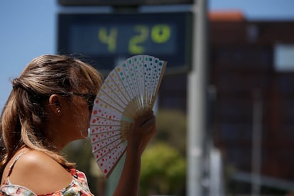 Una mujer se abanica, a principios de agosto, junto a un termómetro de calle en Córdoba.