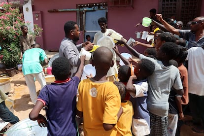 Varios niños sostienen recipientes vacíos mientras voluntarios distribuyen alimentos en la localidad sudanesa de Omdurman, el 3 de septiembre de 2023.