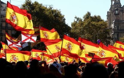 Banderas de España son ondeadas por los manifestantes durante la marcha por Barcelona.