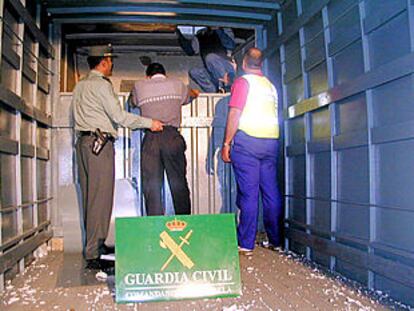 Algunos de los indocumentados, saliendo del doble techo del furgón, ya custodiado por la Guardia Civil.