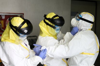 Miembros del Summa se preparan con trajes especiales de protección individual (EPI) contra el coronavirus, en el exterior de un centro hospitalario de Madrid.