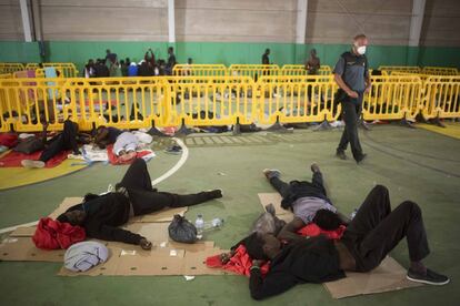 Varios migrantes subsaharianos descansan en el suelo del polideportivo de Los Cortijillos, Los Barrios, Cádiz.