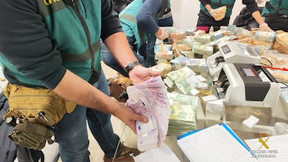 Agentes de la Guardia Civil cuentan el dinero intervenido en la vivienda de uno de los principales detenidos en la Operación Halia, desarrollada en Galicia y Madrid.