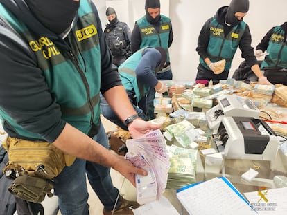 Agentes de la Guardia Civil cuentan el dinero intervenido en la vivienda de uno de los principales detenidos en la Operación Halia, desarrollada en Galicia y Madrid.