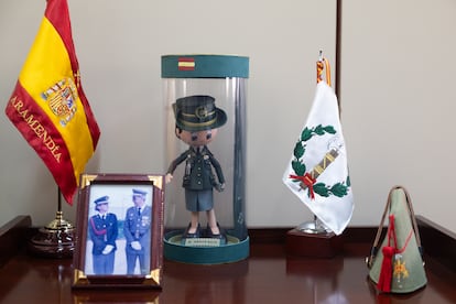Rincón en el despacho de la general Aramendía: bandera de España con la divisa de general y su apellido bordado; fotografía con su padre, el coronel Aramendía, el día de su jura de Bandera; muñeca fofucha personalizada; bandera con el emblema del Cuerpo Jurídico Militar; y un chapiri, gorro de la Legión impuesto cuando fue nombrada legionaria de honor.
