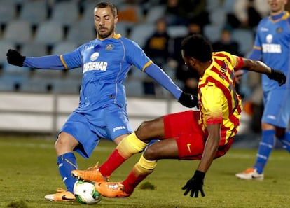 El centrocampista franco-argelino del Getafe, Mehdi Lacen (i), lucha el balón con el camerunés Alexandre Song, del FC Barcelona, durante el partido de vuelta de octavos de final de la Copa del Rey que se disputa esta noche en el Coliseo Alfonso Pérez, en Getafe. 