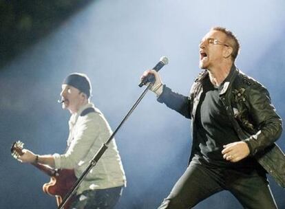 Bono, a la derecha, junto a uno de los componentes de U2, durante el concierto de anoche en el Camp Nou.