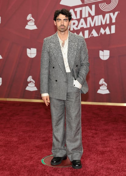  Joe Jonas, con traje gris y camisa blanca.