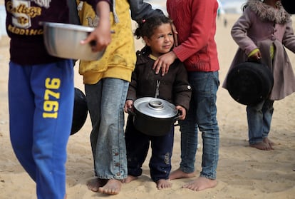 Niños palestinos hacen cola para recibir comida, este martes en Rafah.