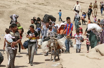 Refugiados sirios cruzan a Irak en el paso de Peshkhabour, en Dahuk, a 430 kilometros al noroeste de Bagdad, en agosto de 2013.