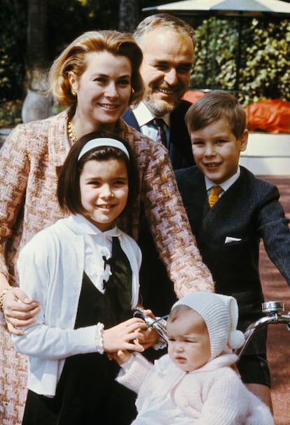 Fue bautizada el 3 de marzo de 1957 en la Catedral de San Nicolás y creció en un ambiente feliz y tranquilo, acompañada por su familia y su niñera, Maureen Woods. Estudió primero en palacio, y después en el colegio monegasco Las Damas de San Mauro. Cada período estival acudía a campamentos de verano en Estados Unidos, país de origen de su madre, junto a sus primos maternos, donde pudo aprender el idioma. En la imagen posan sonrientes en los jardines de palacio Raniero III de Mónaco y Grace Kelly, que celebraban su décimo año de casados junto a sus tres hijos, Carolina, Alberto y Estefanía, cuando solo tenían 9 años, 8 años y 14 meses respectivamente.