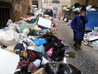 Un niño atraviesa una calle de Nápoles llena de basura.