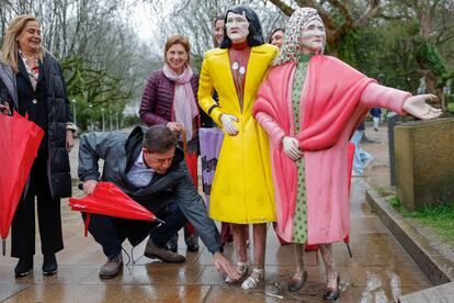 El candidato del PSOE, José Ramón Besteiro, limpia los zapatos de las escultura de 'Las dos Marías', en la Alameda de Santiago de Compostela el 15 de febrero. 
