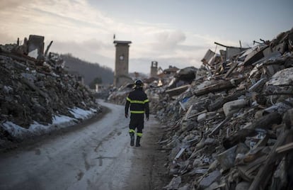 Un bombero camina por lo que un día fue la calle principal de Amatrice.