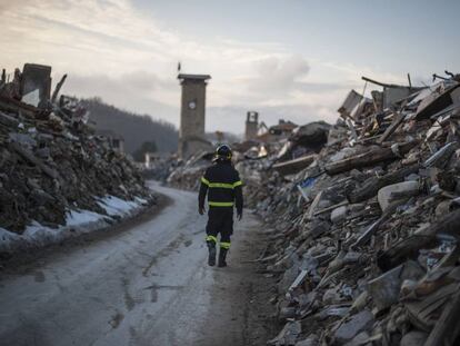 Un bombero camina por lo que un d&iacute;a fue la calle principal de Amatrice.