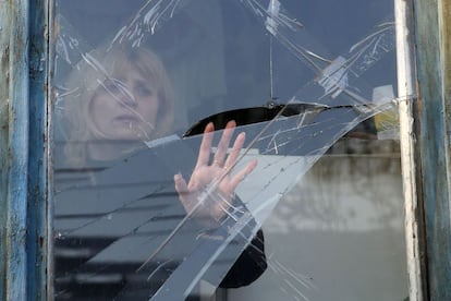 Una mujer inspecciona los daños en una ventana causada por los bombardeos en Donetsk. La lucha se intensificó en el este de Ucrania el sábado cuando los rebeldes separatistas intentaron apoderarse de más territorio antes de la entrada en vigor la tregua.