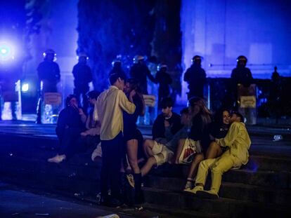 Jóvenes en las escaleras de la plaza de Espanya mientras la Guardia Urbana desaloja la zona en la última madrugada de las fiestas de La Mercè.