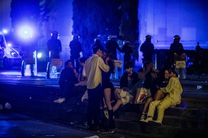 Jóvenes en las escaleras de la plaza de Espanya mientras la Guardia Urbana desaloja la zona en la última madrugada de las fiestas de La Mercè.