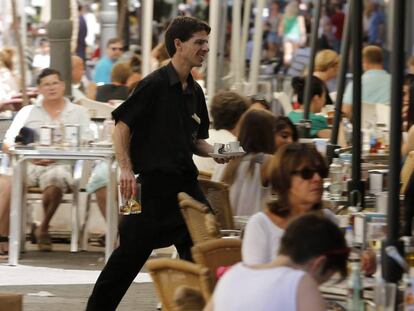 Un camarero trabaja en una terraza en Valencia.