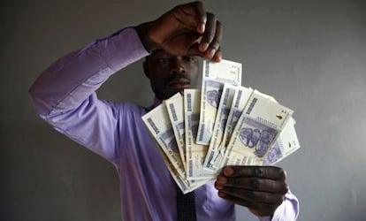 Un hombre muestra varios dólares zimbabuenses, en Harare (Zimbabue).