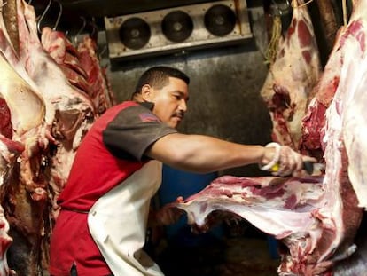 Un carnicero manipula carne en Venezuela.