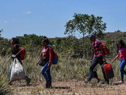 Venezolanos caminan en Pacaraima, Brasil, tras cruzar la frontera. 