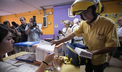 Un cartero lleva el voto por correo a una mesa de L’Hospitalet de Llobregat (Barcelona).