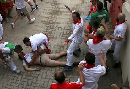 Un herido, durante el primer encierro de San Fermín, es atendido en la entrada de la plaza de toros de Pamplona, este domingo. 