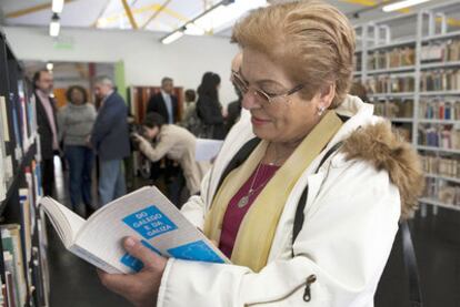 Una mujer lee un libro en la biblioteca pública Cortázar de Buenos Aires.