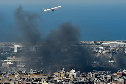 Un avión sortea el humo que ha dejado un ataque aéreo israelí en un bastión de Hezbolá al sur de Beirut.