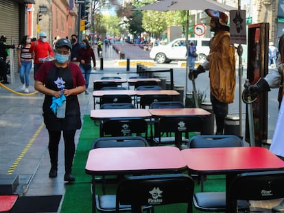 Una trabajadora limpia las mesas de un restaurante en Ciudad de México.