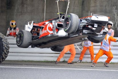 Lewis Hamilton observa como retiran su coche tras su accidente en la primera tanda de los entrenamientos libres