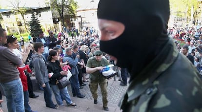 Activistas prorrusos guardan la entrada de la televisi&oacute;n regional en Donetsk. 