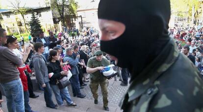 Activistas prorrusos guardan la entrada de la televisión regional en Donetsk.