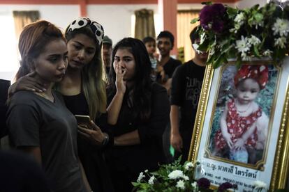 Jiranuch Trirat, de 22 años, consolada por sus amigos frente al retrato de su bebé, asesinada por su padre.