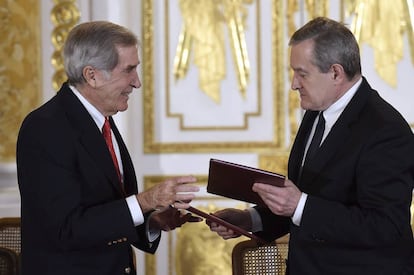 El presidente y fundador del Consejo de la Fundación Princes Czartoryski, el príncipe Adam Karol Czartoryski (izquierda), y el ministro polaco de Cultura, Piotr Glinski, intercambian documentos durante la ceremonia.